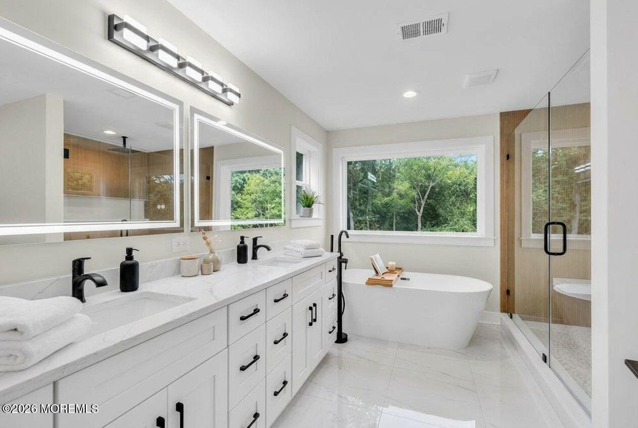 1730 Old Freehold Road Toms River, NJ 08755 - Photo 23 of 41 a bathroom with a double vanity sink a large mirror a bathtub and next to a window