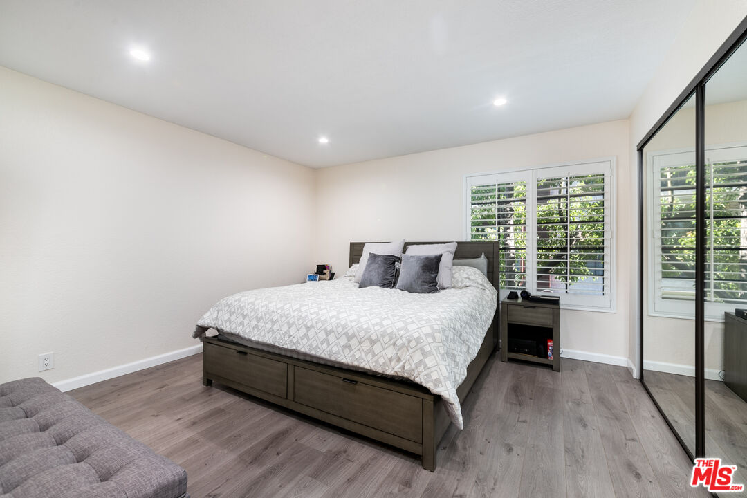 231 Bethany Road, Unit 210 Burbank, CA 91504 - Photo 13 of 22 a spacious bedroom with a bed and wooden floor