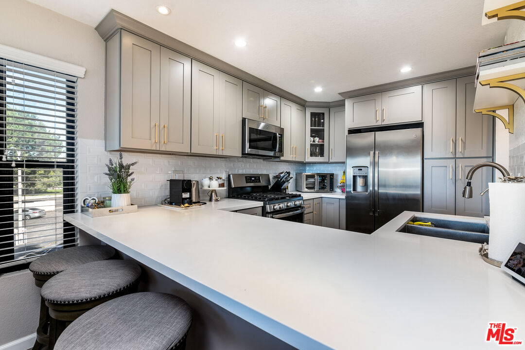231 Bethany Road, Unit 210 Burbank, CA 91504 - Photo 3 of 22 a kitchen with stainless steel appliances a stove a sink a microwave a refrigerator a stove and cabinets