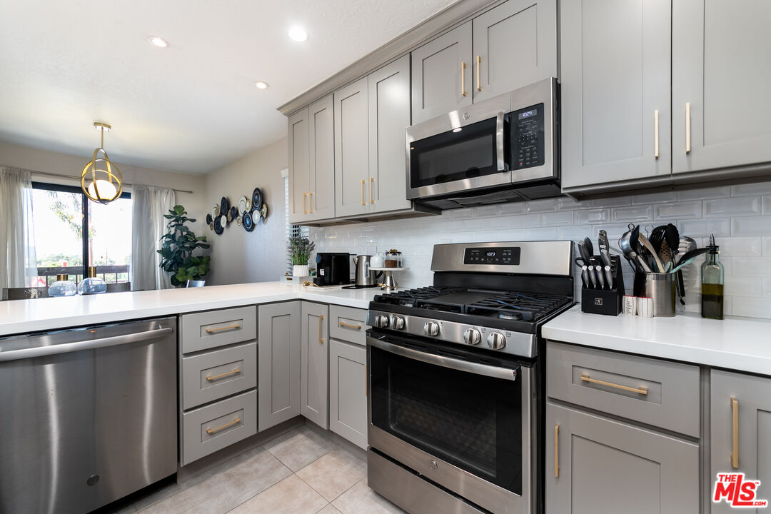 231 Bethany Road, Unit 210 Burbank, CA 91504 - Photo 4 of 22 a kitchen with stainless steel appliances granite countertop grey cabinets a stove a sink and dishwasher