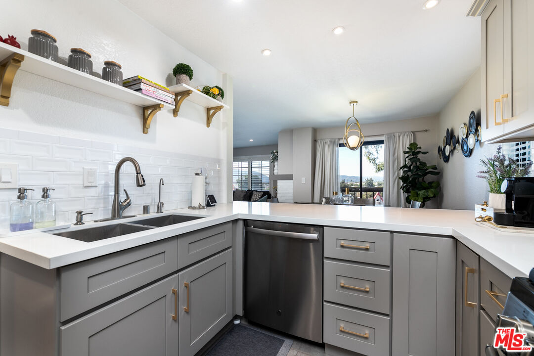 231 Bethany Road, Unit 210 Burbank, CA 91504 - Photo 5 of 22 a kitchen with a sink dishwasher and cabinets with wooden floor