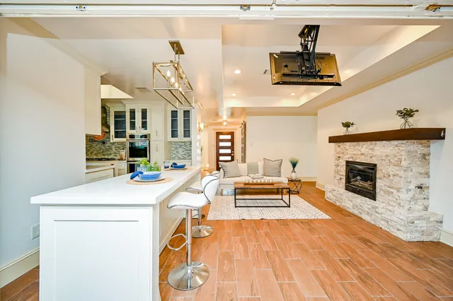 a living room with furniture a fireplace and kitchen view
