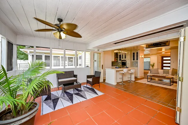 a living room with patio pool table and chairs