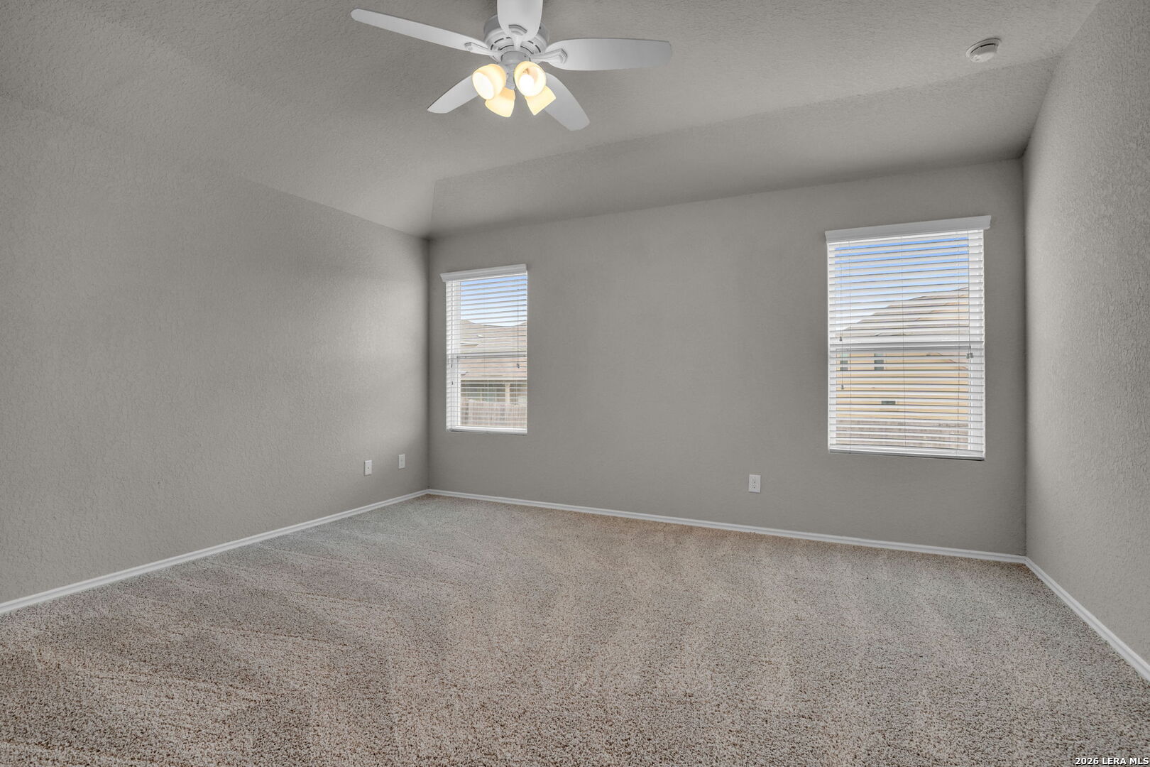 10306 Midsummer Meadow Converse, TX 78109 - Photo 11 of 26 en empty room with windows and chandelier fan