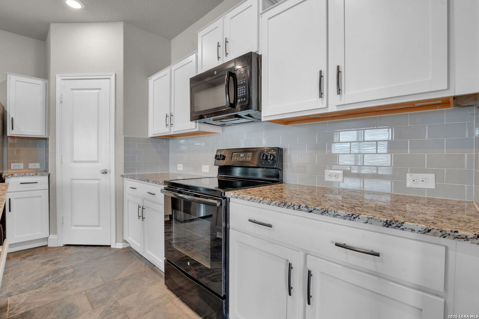 10306 Midsummer Meadow Converse, TX 78109 - Photo 9 of 26 a kitchen with granite countertop white cabinets and a stove