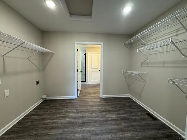 a view of an empty room with wooden floor and closet