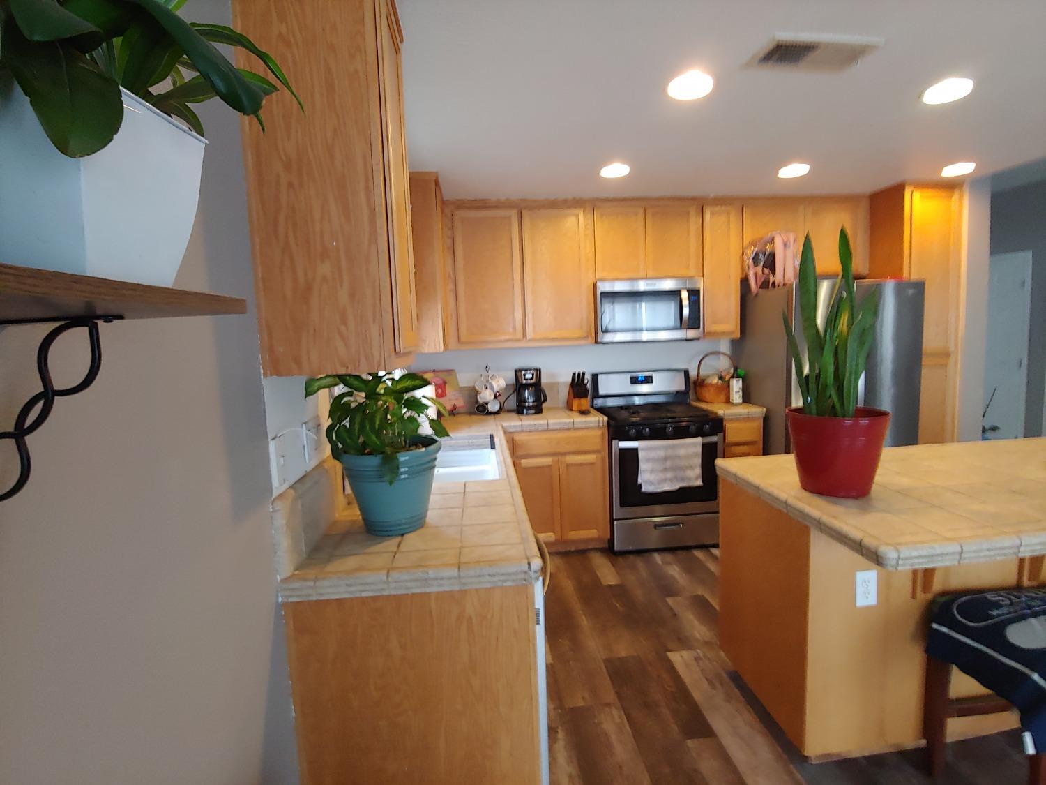 1190 Hazelnut Lane Madera, CA 93637 - Photo 6 of 18 a kitchen with a sink and a refrigerator