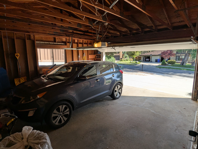 1411 Millbrook Way Bountiful, UT 84010 - Photo 36 of 36 Attached garage featuring exposed wood framing and a concrete floor