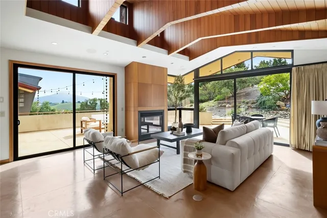 a living room with furniture a table and a large window