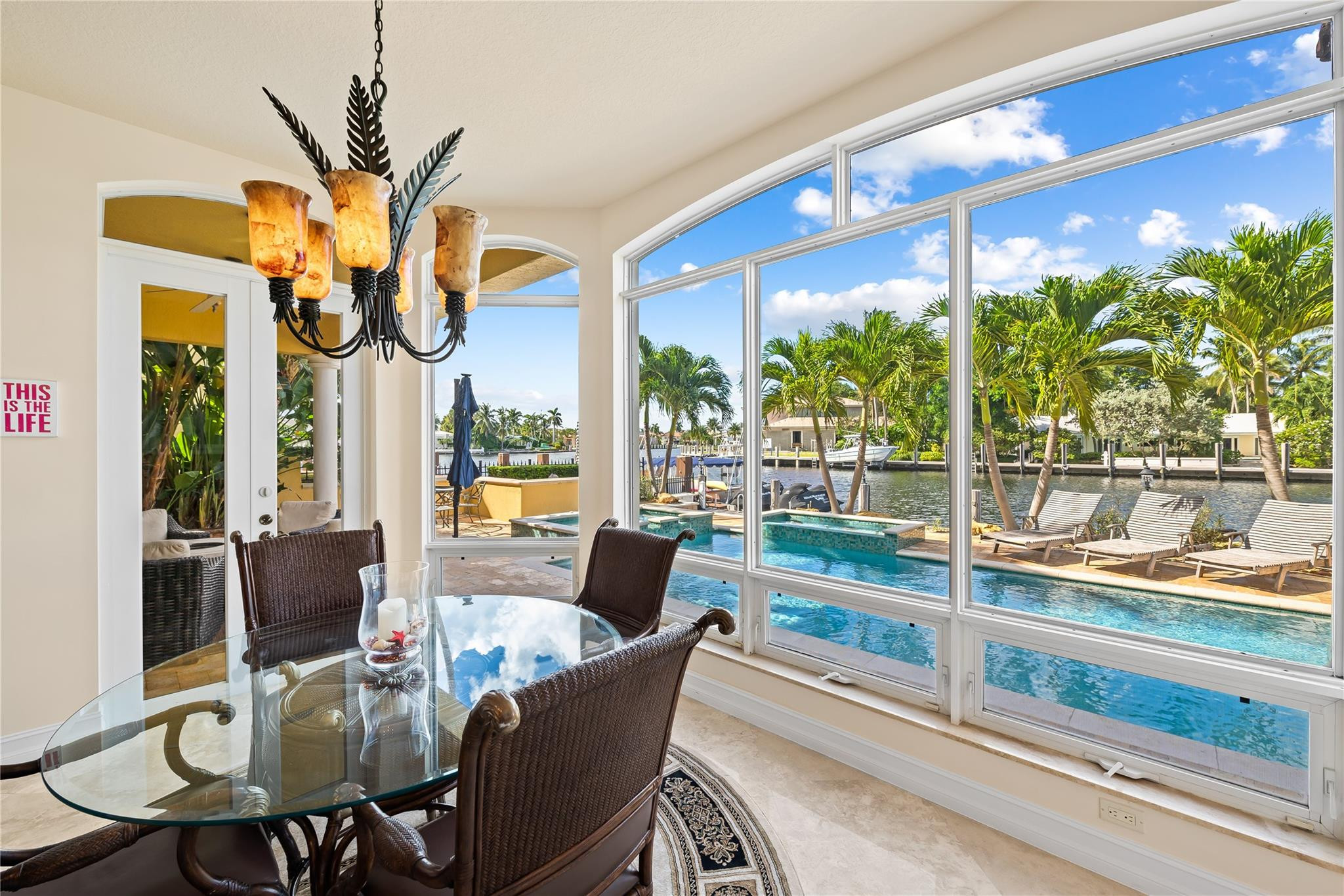 2637 Northeast 28th Court Lighthouse Point, FL 33064 - Photo 29 of 50 a dining room with furniture a large window and palm tree