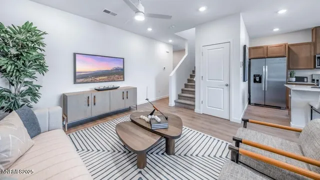 a living room with furniture a flat screen tv and a potted plant