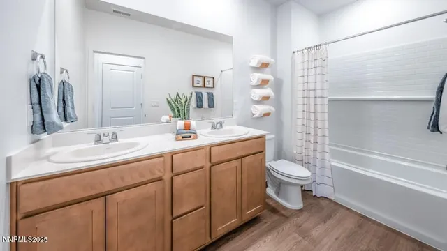 a bathroom with a double vanity sink toilet and shower