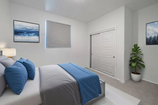 a bedroom with a bed and a potted plant