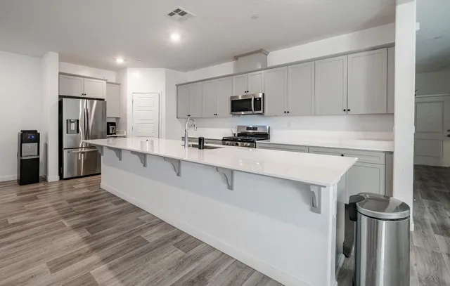 a kitchen with stainless steel appliances a refrigerator sink and microwave