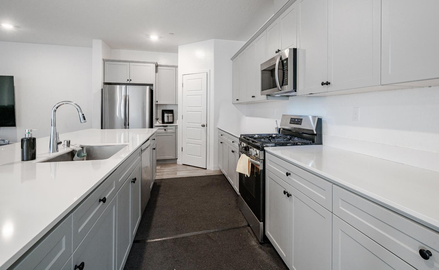 2735 North Redda Road Fresno, CA 93737 - Photo 5 of 20 a kitchen with stainless steel appliances a sink stove refrigerator and cabinets
