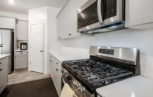 a kitchen with stainless steel appliances granite countertop a stove and a microwave
