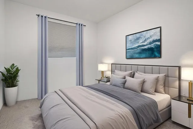 a bedroom with bed and a potted plant