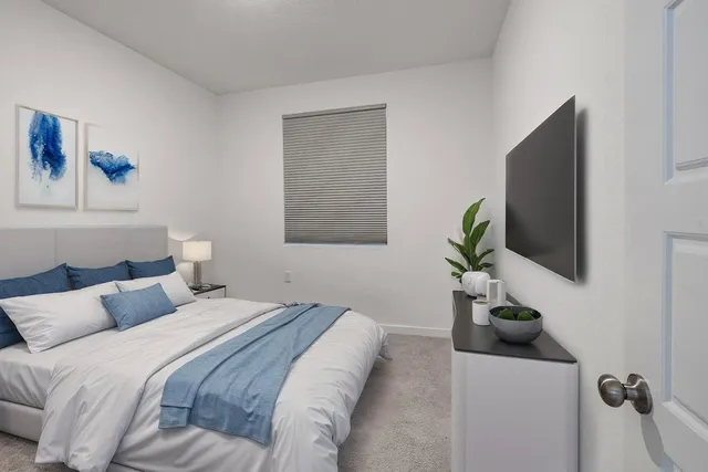 a bedroom with a bed and a flat screen tv