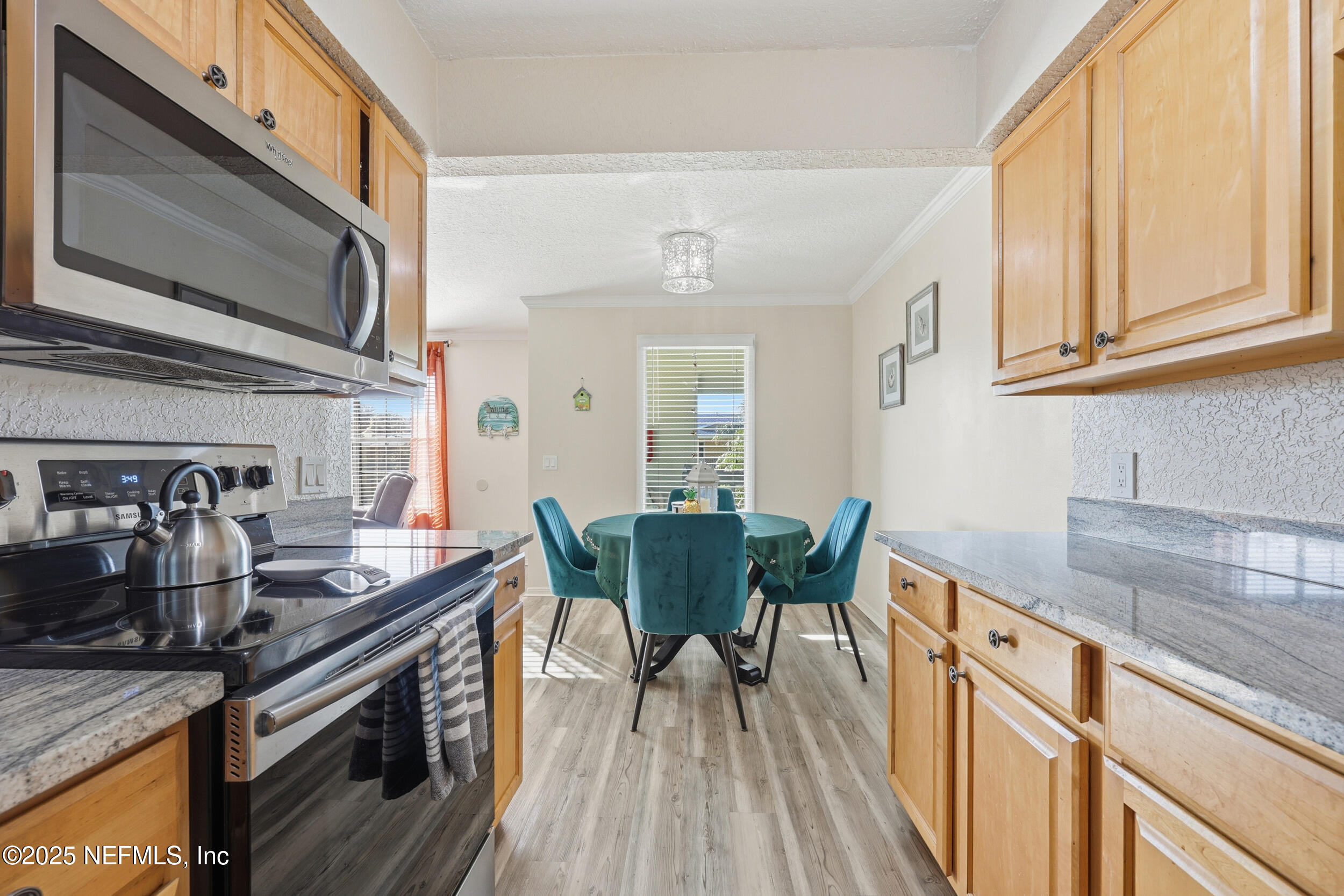 47 Clipper Court St. Augustine, FL 32080 - Photo 18 of 50 a kitchen with stainless steel appliances granite countertop a stove a sink dishwasher and microwave with wooden floor