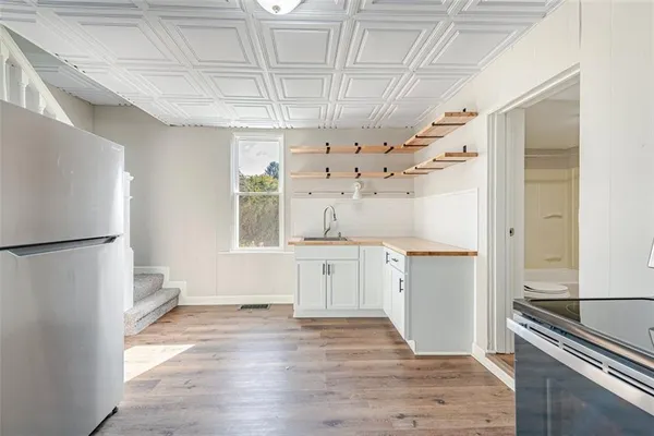 a kitchen with granite countertop a refrigerator and a stove top oven