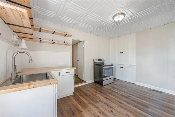 a kitchen with stainless steel appliances granite countertop a sink stove and wooden floor