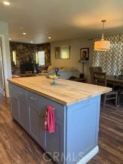 a room with kitchen island granite countertop wooden cabinets and entryway