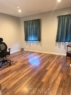 a view of a room with gym equipment and wooden floor