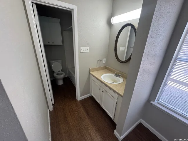 a bathroom with a granite countertop sink and a mirror