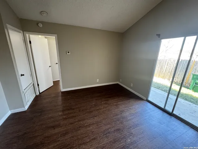 an empty room with wooden floor and a fireplace