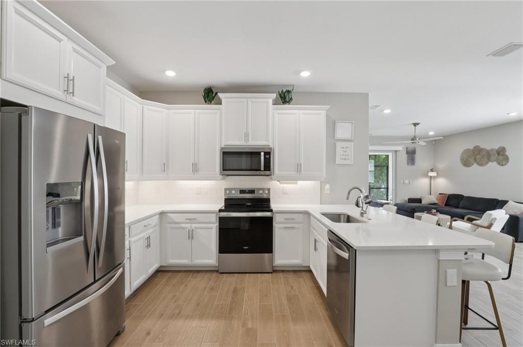 a kitchen with stainless steel appliances a sink stove refrigerator and cabinets