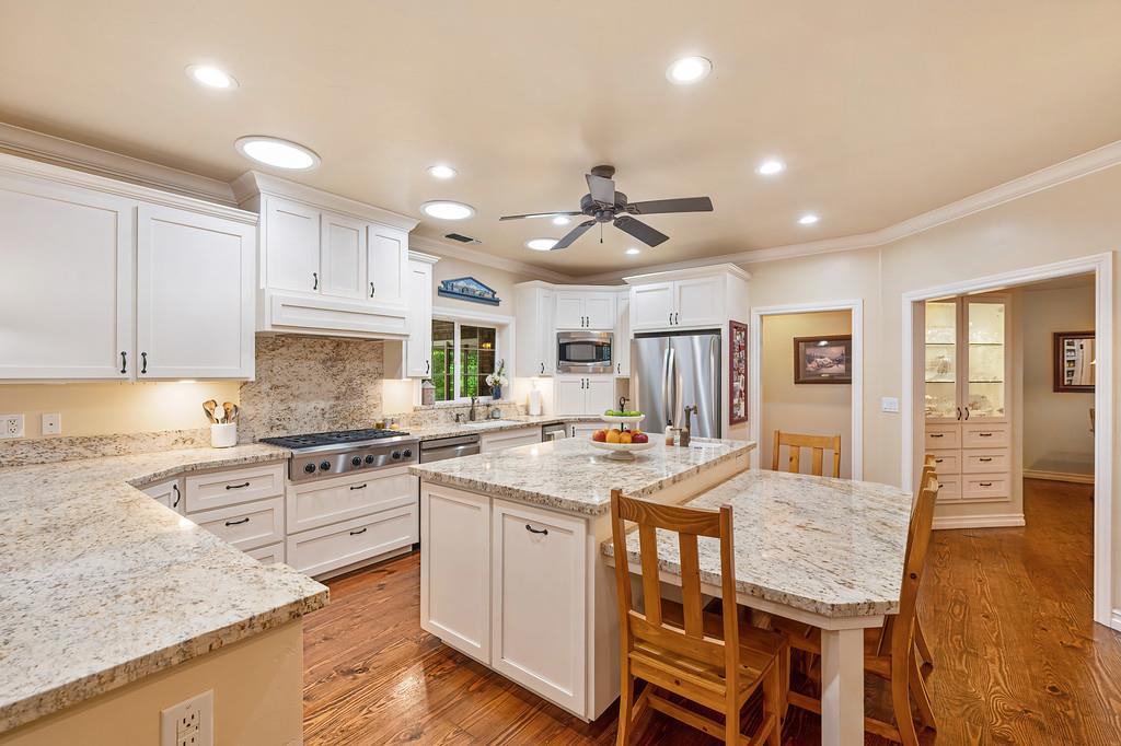 3557 Val Verde Road Loomis, CA 95650 - Photo 14 of 71 a kitchen with stainless steel appliances granite countertop a stove top oven a sink a dining table and chairs