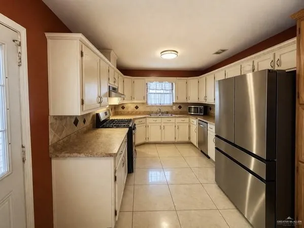 a kitchen with stainless steel appliances granite countertop a refrigerator sink and cabinets