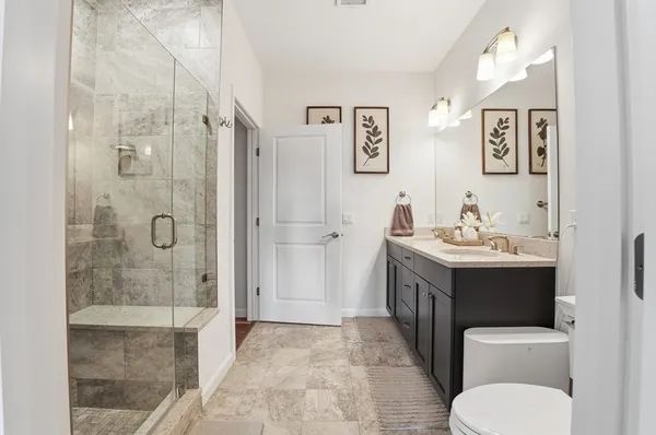 a bathroom with a granite countertop sink toilet and shower