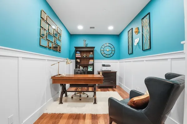 a living room with furniture and paintings on the wall