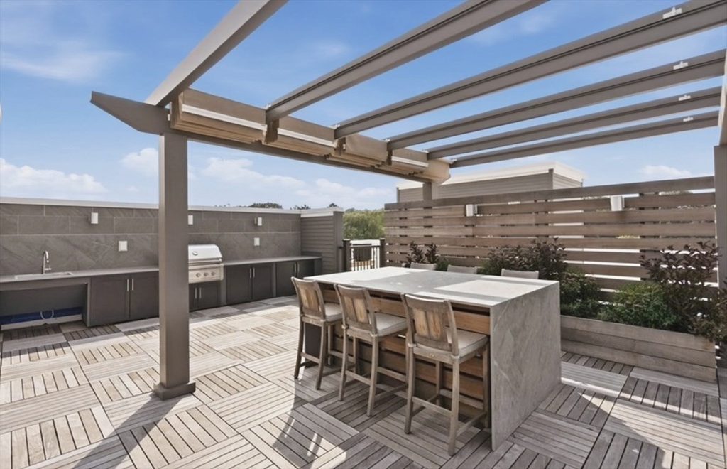 15 Revolution Way, Unit 2205 Canton, MA 02021 - Photo 25 of 34 a view of a patio with table and chairs with wooden floor and fence