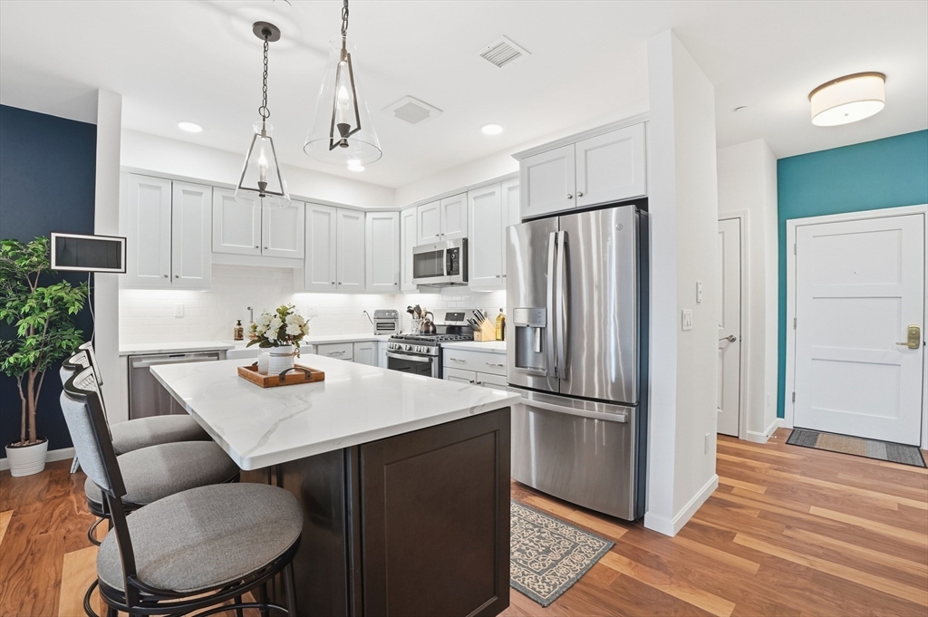 15 Revolution Way, Unit 2205 Canton, MA 02021 - Photo 4 of 34 a kitchen with kitchen island a appliances dining table and chairs