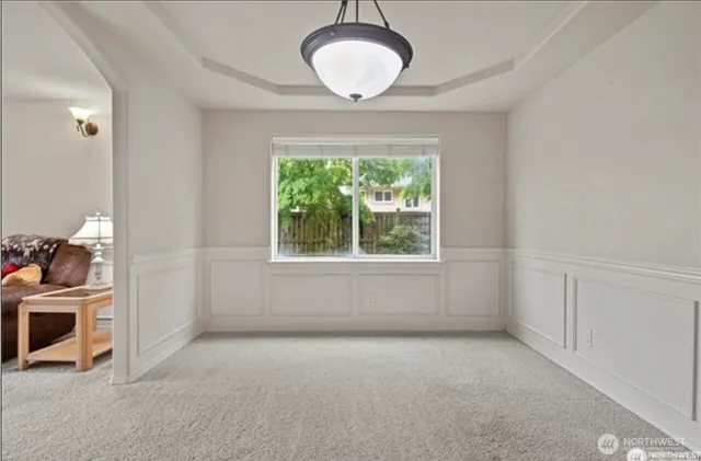 an empty room with a window and kitchen view