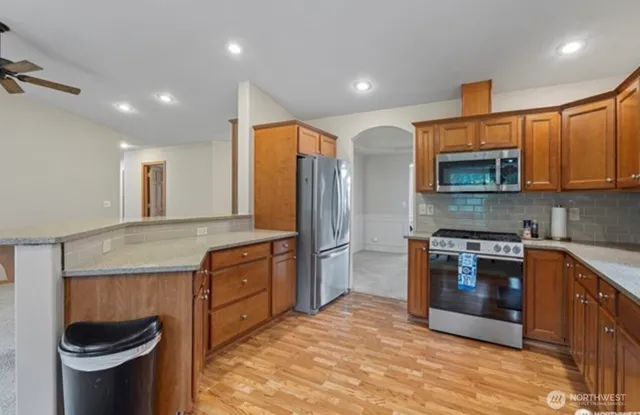 a kitchen with stainless steel appliances granite countertop a stove a sink and a microwave