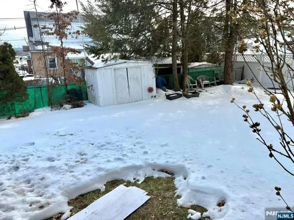 a view of backyard with a table and chairs and a covered with trees