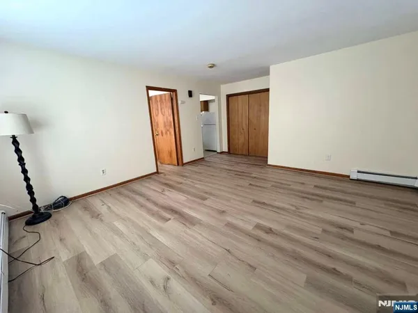 a view of an empty room with wooden floor