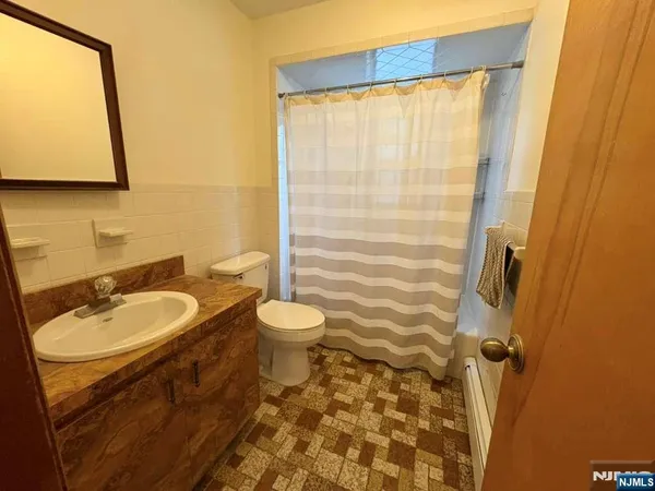a bathroom with a sink a toilet and a mirror