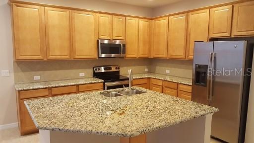 7652 Ripplepointe Way Windermere, FL 34786 - Photo 7 of 21 a kitchen with stainless steel appliances granite countertop a refrigerator sink and cabinets