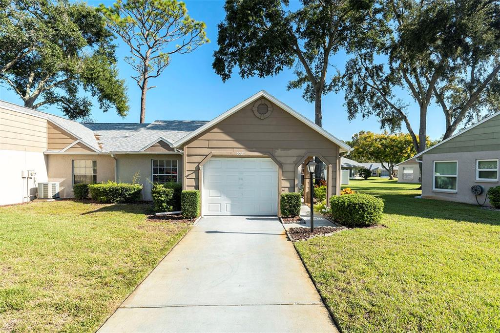 9529 Bunker Hill Court, Unit 9529 New Port Richey, FL 34655 - Photo 1 of 1 a front view of a house with a yard and potted plants