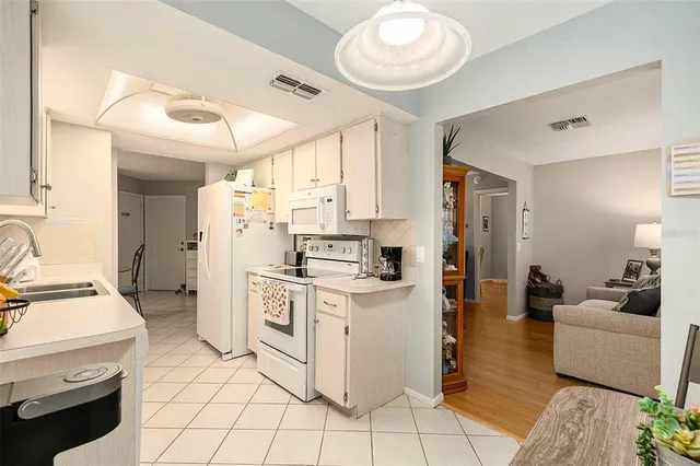 a kitchen with white cabinets and appliances