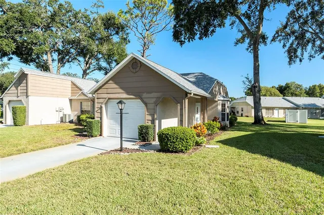 a view of a house with a yard and palm trees
