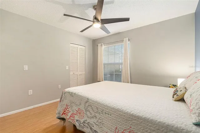 a bedroom with a bed and a ceiling fan