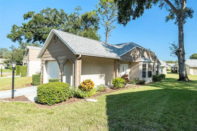 a front view of a house with a garden and plants