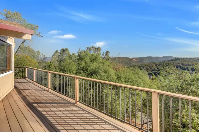 a view of a balcony with wooden floor and fence