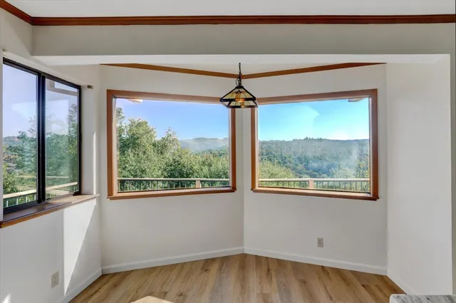a view of a room that has a window and wooden floor