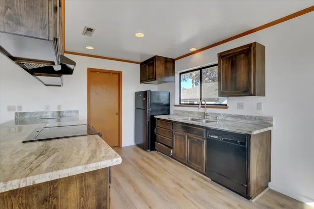 a large kitchen with stainless steel appliances granite countertop a sink stove and refrigerator